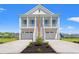 Charming two-story beach home with double garages and a inviting stairway to a cozy porch at 434 Harbour View Dr., Myrtle Beach, SC 29579