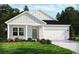 Charming single-story home featuring a two-car garage, light-colored siding, and a beautifully landscaped front yard at 4849 Hopespring St., Myrtle Beach, SC 29579