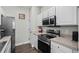 Bright kitchen features stainless steel appliances, white cabinetry, and neutral countertops, creating a modern, functional space at 4933 Crab Pond Ct. # 201, Myrtle Beach, SC 29579