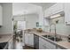 Bright kitchen with stainless steel sink, modern faucet, and white cabinets, complemented by a cozy dining area at 4933 Crab Pond Ct. # 201, Myrtle Beach, SC 29579