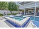 Close up of blue tiled hot tub with access to pool in a fenced backyard with outdoor seating at 500 23Rd Ave. S, North Myrtle Beach, SC 29582