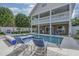 Backyard pool and spa with lounge chairs, landscaping, and two-story house with balconies at 500 23Rd Ave. S, North Myrtle Beach, SC 29582