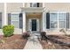 Welcoming front entrance featuring a covered porch, black door, and meticulous landscaping at 636 Pistoia Ln. # 636, Myrtle Beach, SC 29579