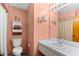 Bathroom featuring pink walls, a vanity with a bright mirror and a toilet with a towel rack above it at 6813 Porcher Dr. # 21, Myrtle Beach, SC 29572