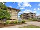 Exterior shot of Heron Pond buildings with a blue sky and the complex sign with landscaping at 6813 Porcher Dr. # 21, Myrtle Beach, SC 29572
