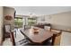 A dining room with a wooden table and view to a living room with a sofa, rug, and view to the outside at 6813 Porcher Dr. # 21, Myrtle Beach, SC 29572