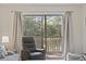 Living room with a recliner, sliding glass doors to a deck, and views of the water at 69 Pinehurst Ln. # 3-F, Pawleys Island, SC 29585