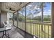 Relaxing screened porch with chairs, a fan, and a picturesque view of the lake at 69 Pinehurst Ln. # 3-F, Pawleys Island, SC 29585