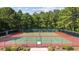 Two fenced tennis courts, one red and one green, surrounded by lush trees at 69 Pinehurst Ln. # 3-F, Pawleys Island, SC 29585