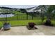 A serene backyard featuring a patio with a fire pit and views of the pond, with a fence and lush green space at 692 Cherry Blossom Dr., Murrells Inlet, SC 29576