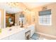 Bathroom featuring double sinks, vanity area, and window with natural light and tiled shower at 712A Ocean Blvd. S, Surfside Beach, SC 29575