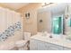 Bright bathroom with a white single sink vanity, white toilet and blue fish themed shower curtain at 712A Ocean Blvd. S, Surfside Beach, SC 29575