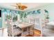 Dining room with coastal decor features wood table and chairs, unique lighting, and decorative window treatments at 712A Ocean Blvd. S, Surfside Beach, SC 29575