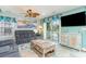 The living room boasts a comfortable gray couch, beach themed decor, and sliding glass doors to the patio at 712A Ocean Blvd. S, Surfside Beach, SC 29575