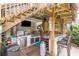 Fully equipped outdoor kitchen with a grill, mini fridge, bar, and entertainment setup, perfect for outdoor dining at 712A Ocean Blvd. S, Surfside Beach, SC 29575