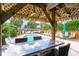 Beautiful pool area with tables and lounge chairs, shaded by a tiki hut, ideal for entertaining guests at 712A Ocean Blvd. S, Surfside Beach, SC 29575