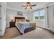 Bedroom features a ceiling fan, a large window, a bed with yellow pillows, and neutral walls at 7317 Lieth Ln., Sunset Beach, NC 28468