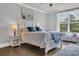 Comfortable bedroom featuring a large window, stylish decor, and wood-look floors at 7317 Lieth Ln., Sunset Beach, NC 28468