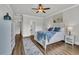 Bright bedroom featuring a ceiling fan, hardwood floors, a decorative rug, and soothing wall art at 7317 Lieth Ln., Sunset Beach, NC 28468