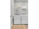 A bright laundry room equipped with a Whirlpool washer, dryer, and storage shelves at 7317 Lieth Ln., Sunset Beach, NC 28468