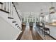 Open living space with hardwood floors, large windows, staircase, and kitchen with island at 7317 Lieth Ln., Sunset Beach, NC 28468