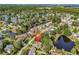 Aerial view showcasing the house and surrounding community with a scenic lake and lush greenery at 86 Black River Rd., Myrtle Beach, SC 29588