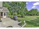 View of a cozy outdoor patio with a grill, surrounded by a well-maintained lawn and lush green trees at 86 Black River Rd., Myrtle Beach, SC 29588