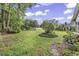 Spacious backyard featuring a lush lawn, mature trees, and garden areas perfect for outdoor enjoyment at 86 Black River Rd., Myrtle Beach, SC 29588