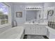 Bright bathroom featuring a soaking tub, double vanity, and natural light from the window at 86 Black River Rd., Myrtle Beach, SC 29588