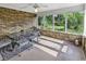 Screened porch with brick accent wall and outdoor dining setup overlooking the landscaped backyard at 86 Black River Rd., Myrtle Beach, SC 29588