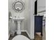 Charming powder room features pedestal sink, decorative mirror, and stylish wood-look floors at 86 Black River Rd., Myrtle Beach, SC 29588