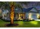Charming home exterior with a well-lit palm tree in the front yard at twilight at 915 Palmetto St., Georgetown, SC 29440