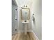 Stylish powder room featuring a pedestal sink, decorative mirror, and modern lighting at 915 Palmetto St., Georgetown, SC 29440