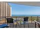 Condo balcony overlooking the beach, pool area, and ocean with table and chairs at 100 North Beach Blvd. # 515, North Myrtle Beach, SC 29582