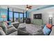 Living area showcasing balcony access, ceiling fan, sectional couch, and entertainment center at 100 North Beach Blvd. # 515, North Myrtle Beach, SC 29582
