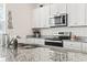 Bright kitchen featuring white cabinets, granite counters, stainless steel appliances, and hardwood flooring at 1020 Sennema Circle, Myrtle Beach, SC 29588
