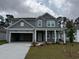New two-story home featuring a covered entryway, gray siding, attached two-car garage and a green lawn at 1023 Laconic Dr., Myrtle Beach, SC 29588