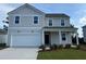 Charming two-story home with neutral siding, a front-entry two-car garage, and a well-manicured lawn at 1035 Laconic Dr., Myrtle Beach, SC 29588