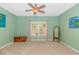Bright bedroom with neutral carpet, ceiling fan and window with curtains; features chest and full length mirror at 1050 Hagley Dr., Pawleys Island, SC 29585