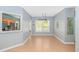 Open dining room with wood floors, decorative lighting, and a pass-through to the kitchen at 1050 Hagley Dr., Pawleys Island, SC 29585