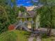 Charming two-story home with a lovely porch and staircase nestled among lush trees at 1050 Hagley Dr., Pawleys Island, SC 29585