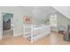 Upstairs hallway with light wood floors and white banister railing and multiple rooms nearby at 1050 Hagley Dr., Pawleys Island, SC 29585