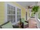 Inviting porch with seating area, ceiling fan, and hanging plants, perfect for relaxing outdoors at 1050 Hagley Dr., Pawleys Island, SC 29585