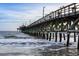 Scenic pier view with wooden structure reaching into the ocean, topped with seagulls under a blue sky at 1058 Sea Mountain Hwy. # 4-203, North Myrtle Beach, SC 29582