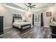 Bedroom featuring a tray ceiling with fan, wood look floors and two windows at 109 Obd Way, Myrtle Beach, SC 29588