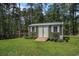 Backyard shed with green siding and white trim, surrounded by a well-manicured lawn and lush greenery at 109 Obd Way, Myrtle Beach, SC 29588