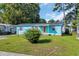 Charming home featuring a well-manicured lawn, teal siding and purple shutters, creating a welcoming curb appeal at 1107 Blue Ridge Trail, North Myrtle Beach, SC 29582