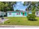 Charming home featuring a well-manicured lawn, teal siding and purple shutters, creating a welcoming curb appeal at 1107 Blue Ridge Trail, North Myrtle Beach, SC 29582