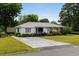 Inviting home exterior with a spacious driveway, lush greenery, and a well-maintained lawn at 1127 Pine Dr., Myrtle Beach, SC 29577