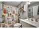Cozy bathroom featuring a vanity sink, a toilet, shower with a beach themed curtain and a decorative shelving unit at 113 Adelphia Rd., Loris, SC 29569